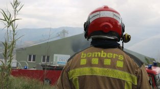 Un bomber observa la fàbrica Decopiscines un cop l'incendi ja està controlat