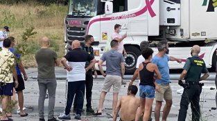 El camioner que ha provocant l'accident, sense samarreta, Davant un agent de la Guàrdia Civil i altres conductors