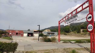 Pancarta i control de gàlib a primer terme i parc de bombers al fons