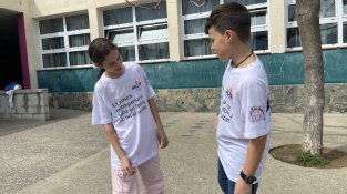 Llegint la samarreta que els ha dissenyat l'escola