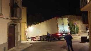 Un camió articulat queda encallat al centre urbà després d’intentar girar en un carrer estret
