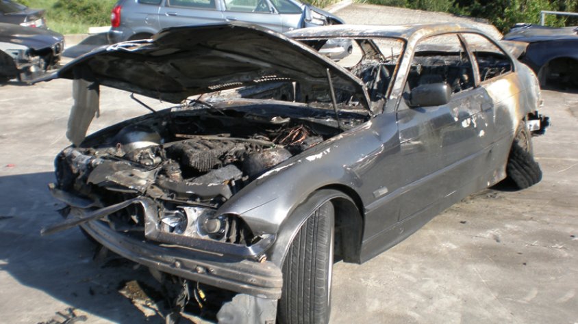 El vehicle accidentat i calcinat, un BMW 320, al centre de desballestament de la Jonquera