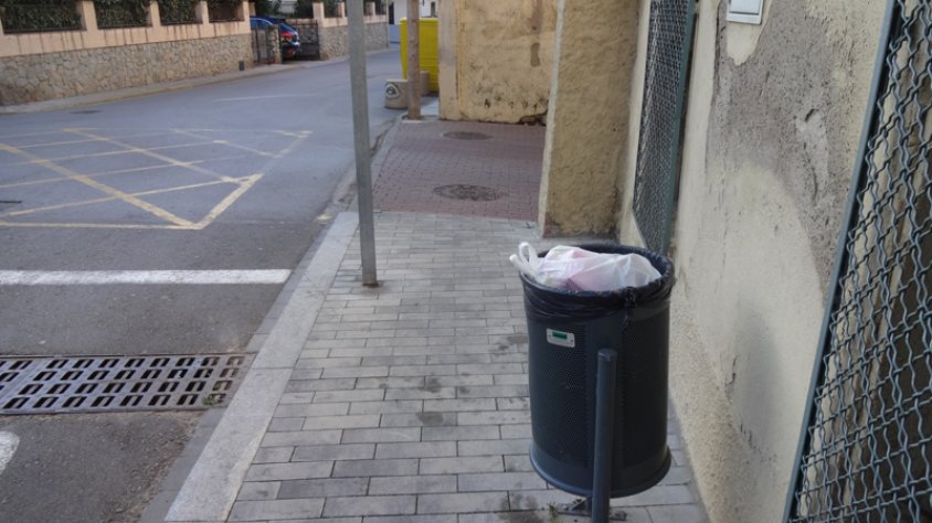 Una paperera plena de bosses de residus domèstics a la zona del casc antic de la Jonquera