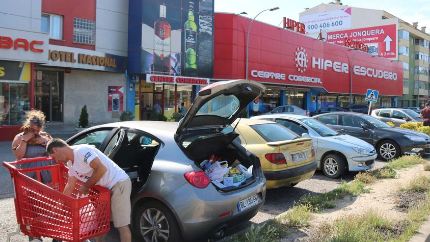 Turistes o compradors francesos davant un dels Supermercats Escudero de la Jonquera