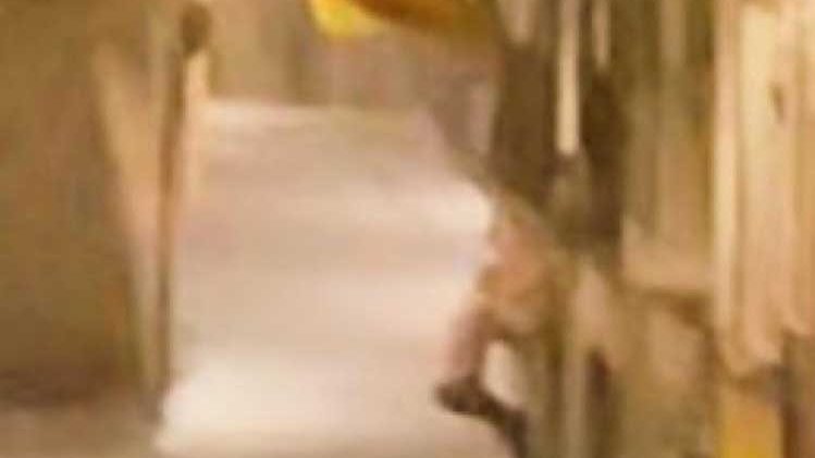 Imatge de l'intent de pujar a un balcó del carrer Major per treure una estelada