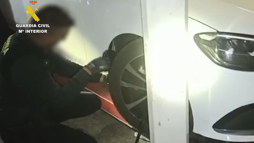 Un dels agents traient la droga del vehicle