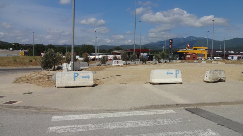 Un pas de vianants convida a entrar directament en un aparcament de sorra